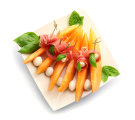 Delicious melon with prosciutto and mozzarella cheese on white background