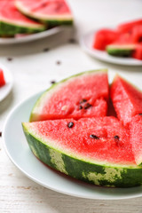 Plate with slices of ripe watermelon on white table