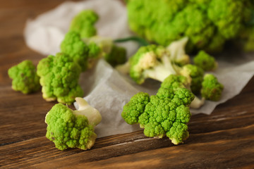 Green cauliflower cabbage on wooden table, closeup