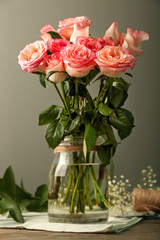 Vase with beautiful roses on wooden table