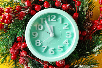 Fototapeta na wymiar Alarm clock with fir wreath on color background, closeup. Christmas countdown