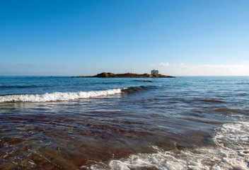Picturesque small Chapel on island across Malia beach, Crete. Greece