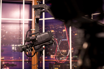 Camera in studio broadcasting news.