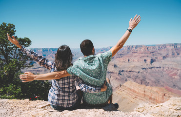 USA, Arizona, Grand Canyon National Park, back view of couple sitting side by side looking at view