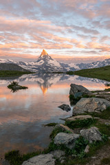 Obraz premium Morning shot of the golden Matterhorn (Monte Cervino, Mont Cervin) and Stellisee lake. Sunrise view of majestic mountain landscape. Swiss Alps.