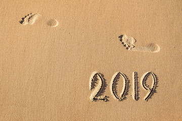 Fototapeta na wymiar 2019 year written on the beach sand
