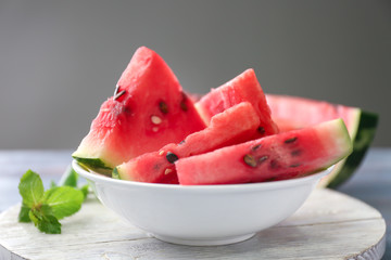 Bowl with slices of watermelon on table