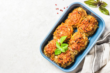 Oven baked chicken and vegetable rissoles in baking dish. Top view, space for text.