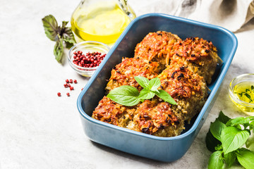 Oven baked chicken and vegetable rissoles in baking dish. Selective focus, space for text.