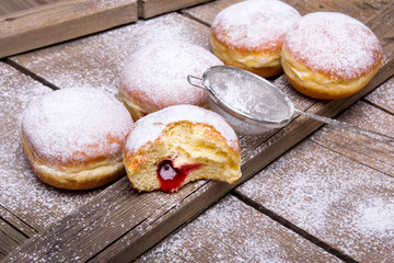 Traditional Polish donuts on wooden background.  Tasty doughnuts with jam.