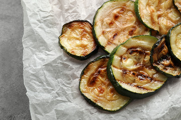 Tasty grilled zucchini on parchment paper, closeup