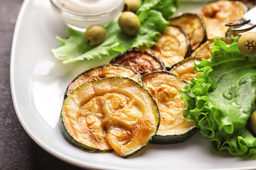 Plate with tasty grilled zucchini on grey table, closeup