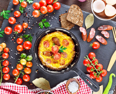 fried omelette from chicken eggs with red cherry tomatoes