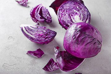 Whole and cut red cabbage on grey table