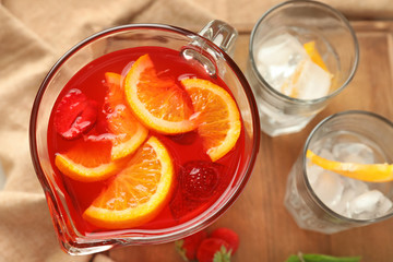 Fresh summer cocktail in glass jug on wooden board, closeup