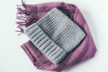 Gray woolen knitted hat and pink scarf on a white background