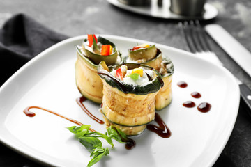 Tasty zucchini rolls with sauce on plate
