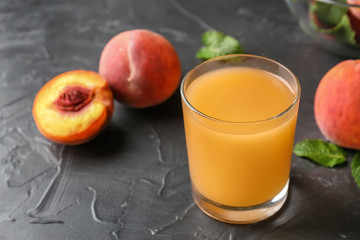 Peach juice in glass on dark textured table