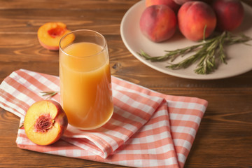 Peach juice in glass on wooden table