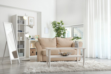 Modern room interior with big mirror, table and stylish sofa