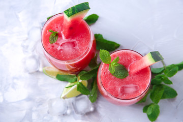 Glasses with fresh watermelon smoothie on light table