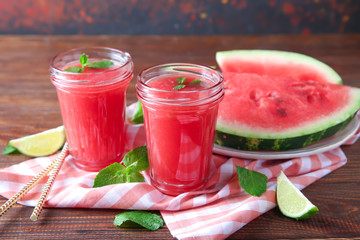 Jars with fresh watermelon smoothie on wooden table