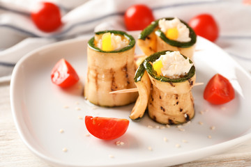 Tasty zucchini rolls with cheese on plate