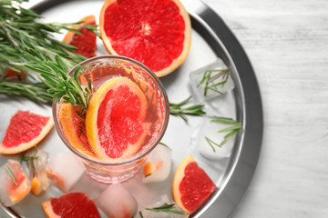 Fresh grapefruit cocktail with rosemary in glass on metal tray