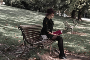 girl read the book in the autumn park 