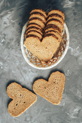 Rye bread in the shape of heart cut into slices on a gray background