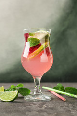 Glass of fresh raspberry mojito on grey table
