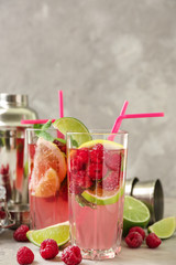 Glasses of fresh raspberry mojito on light table