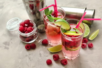 Glasses of fresh raspberry mojito on light table