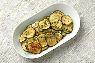 Plate with tasty grilled zucchini on light table