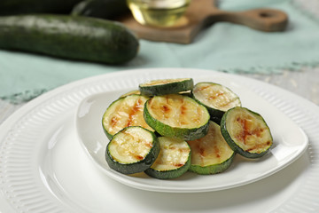 Plate with tasty grilled zucchini on table, closeup