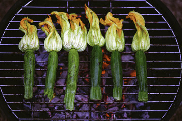 Gegrillte Zucchiniblüten auf einem Grill mit Kohle