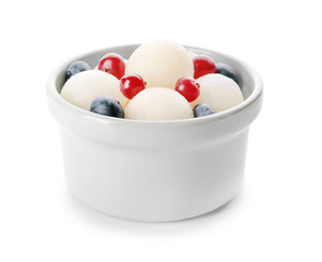 Bowl with tasty melon balls and berries on white background