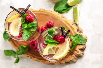 Glasses of fresh raspberry mojito on board
