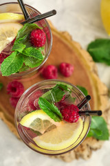 Glasses of fresh raspberry mojito on board