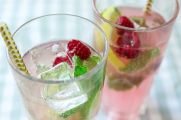 Glasses of fresh raspberry mojito on table, closeup