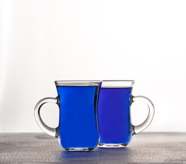 Cups of butterfly pea tea isolated on white background