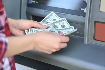 Woman with dollar banknotes near cash machine, closeup