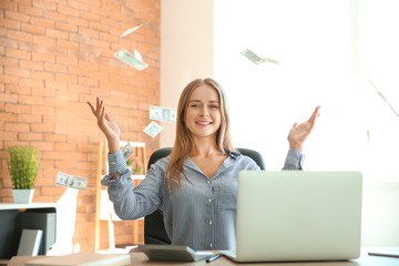 Happy businesswoman with lot of money in office