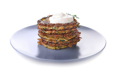 Plate with stack of zucchini pancakes and sauce isolated on white