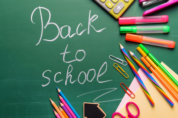 Stationery and words BACK TO SCHOOL written on chalkboard