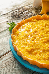 Board with delicious lemon pie on wooden table, closeup