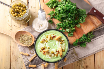 Composition with delicious zucchini soup on wooden table