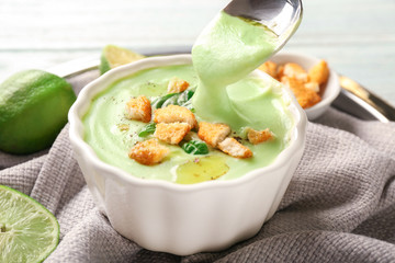 Eating of delicious zucchini soup from bowl, closeup