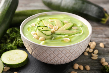 Bowl with delicious zucchini soup on table, closeup