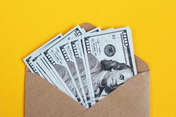 Paper envelope with money on a yellow background. - 220103767